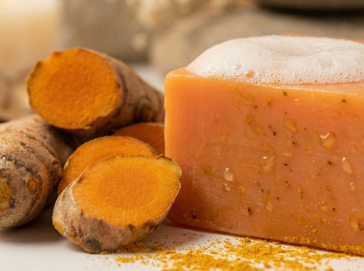 Golden Glow Turmeric Facial Soap bar with fresh turmeric roots and foam on top, highlighting natural skincare ingredients and brightening properties